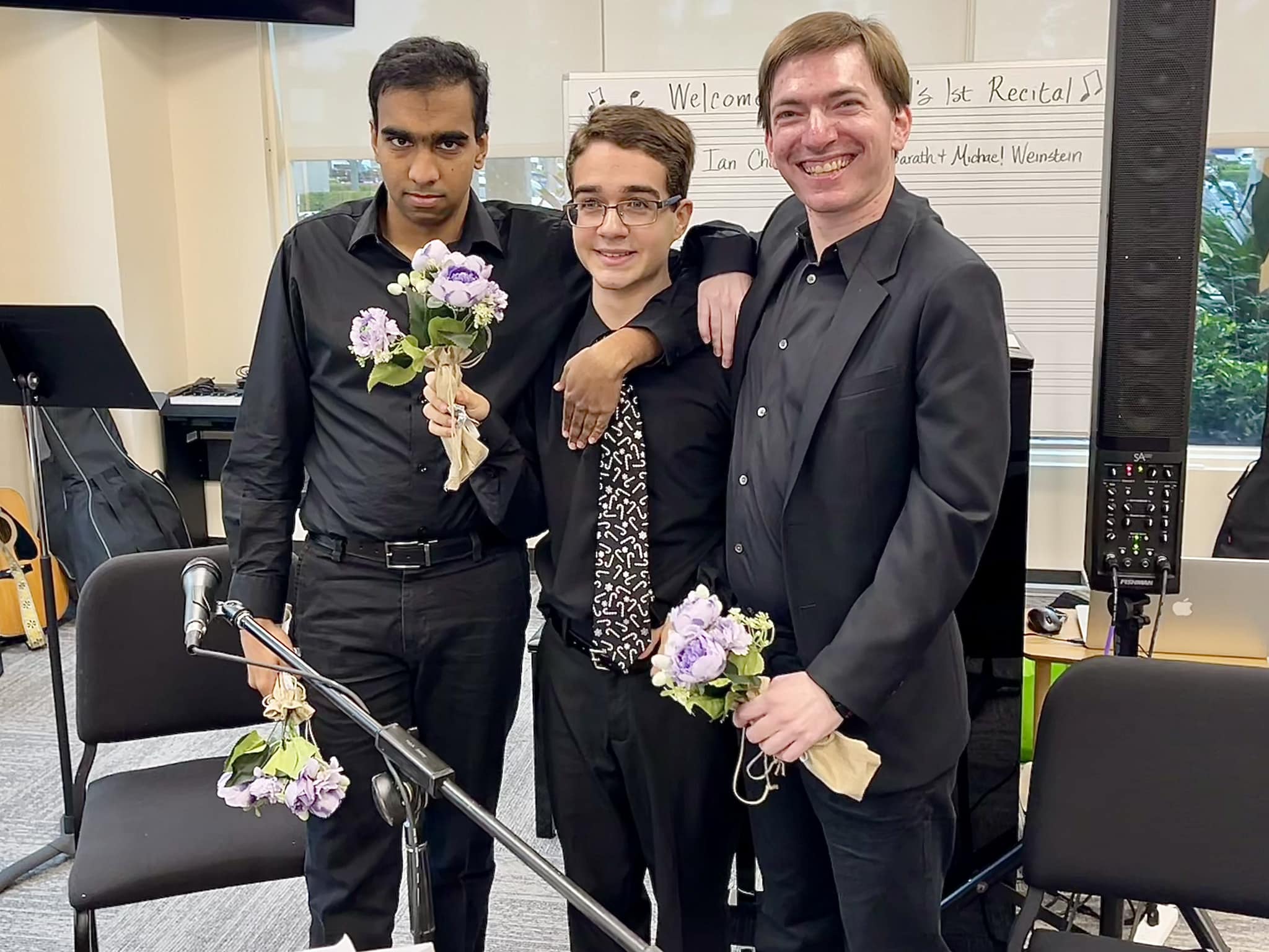 Students after their recital, holding flowers and smiling proudly